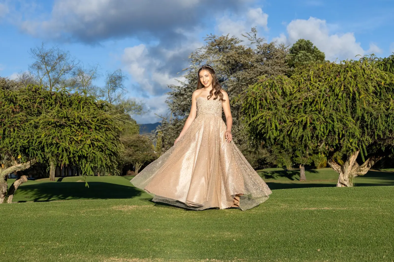 Quinceañera girando su vestido en un campo de golf