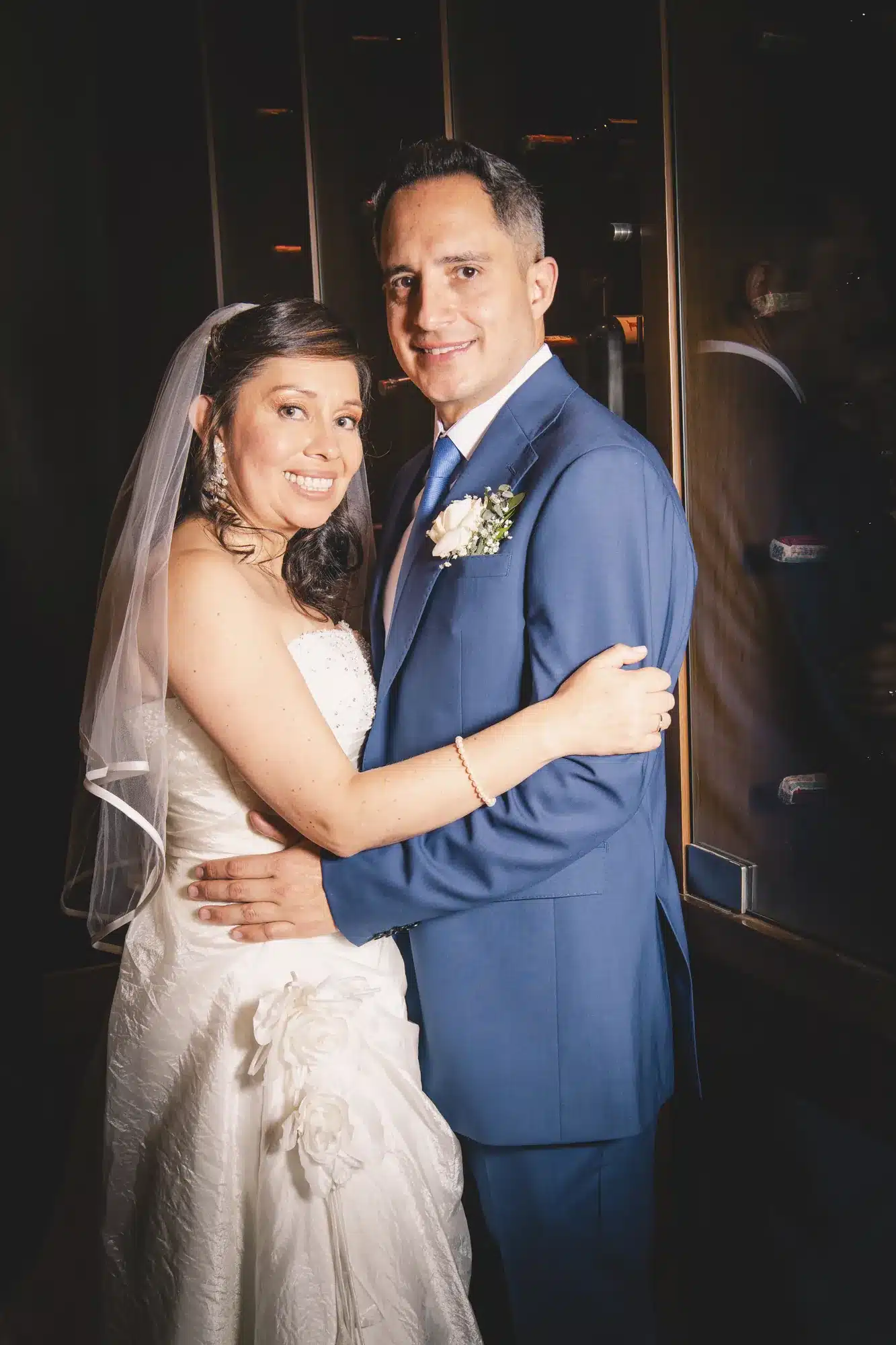 Abrazo de novios con luz de flash en interior