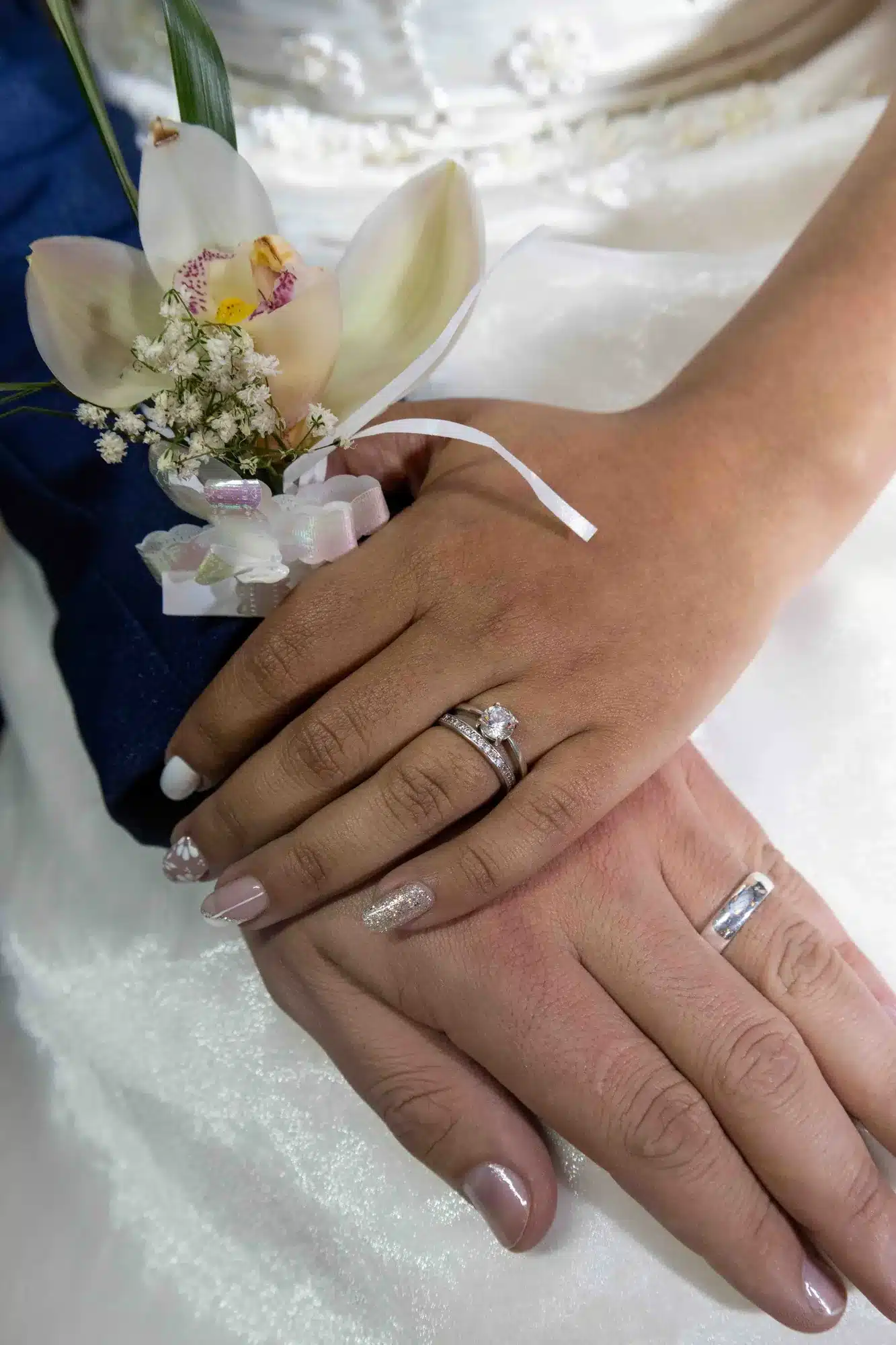 Anillo y manos de la novia con el ramillete del novio