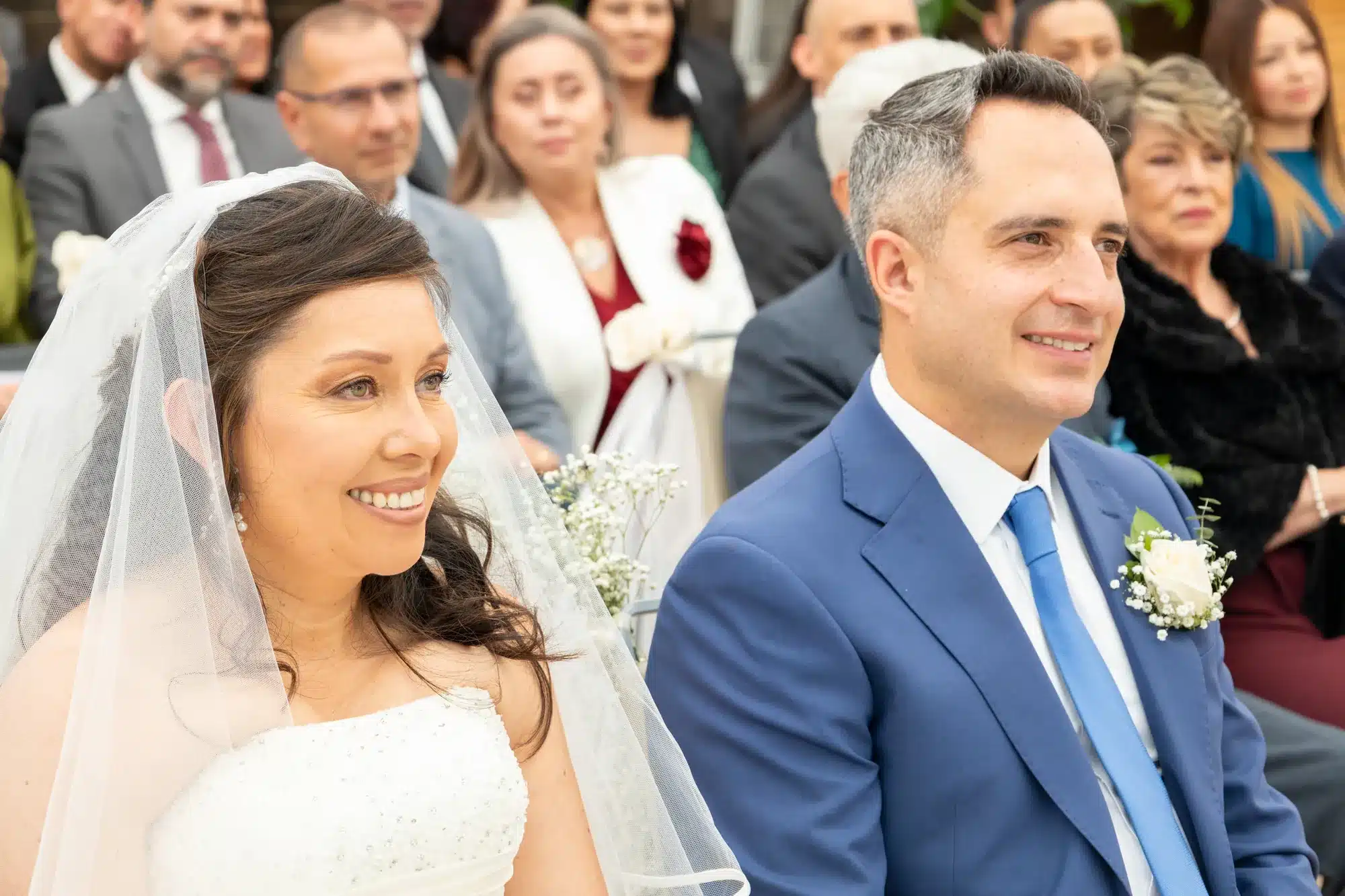 Novia sonriendo junto al novio durante la ceremonia