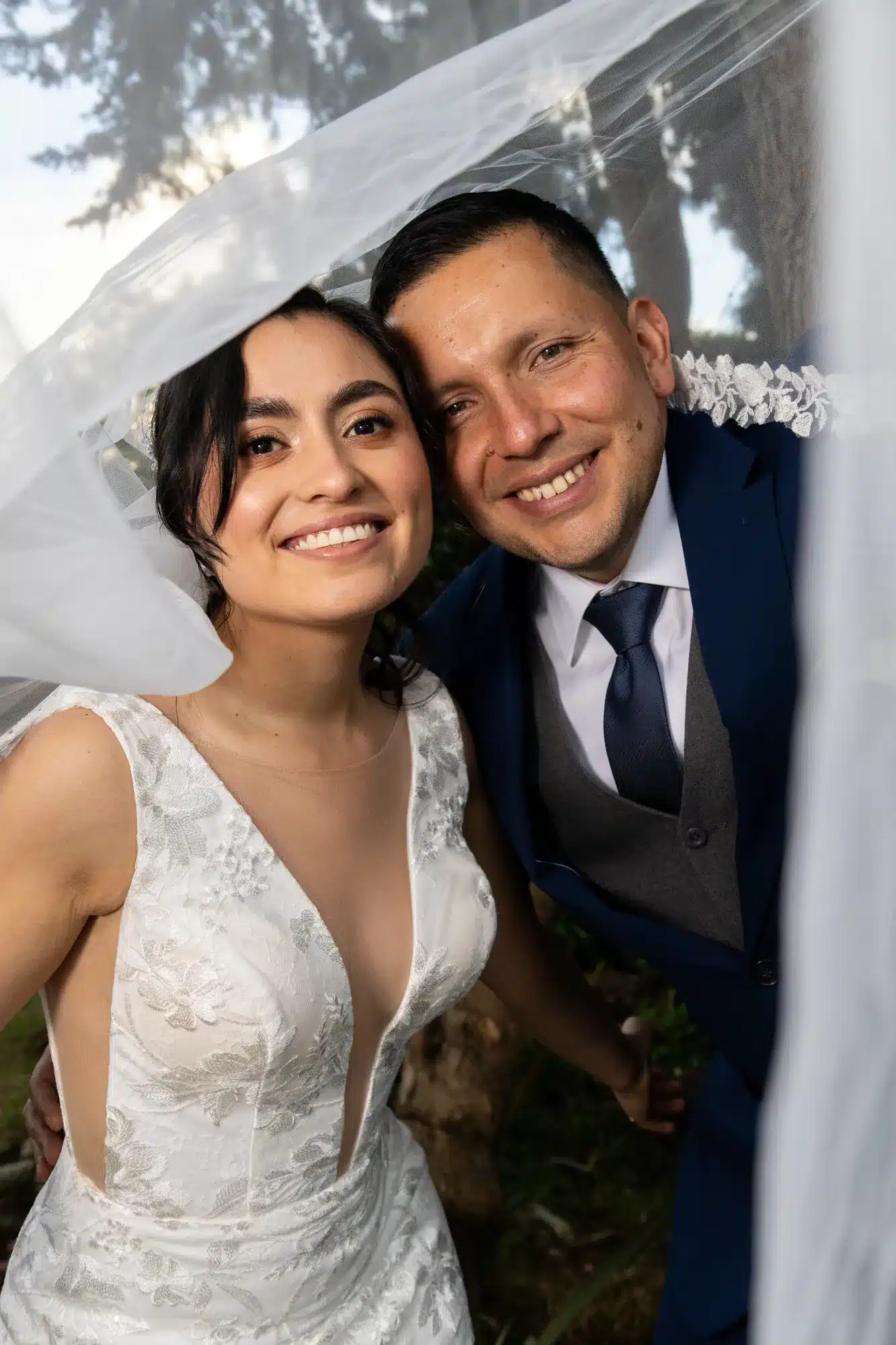 Novios bajo el velo sonriendo