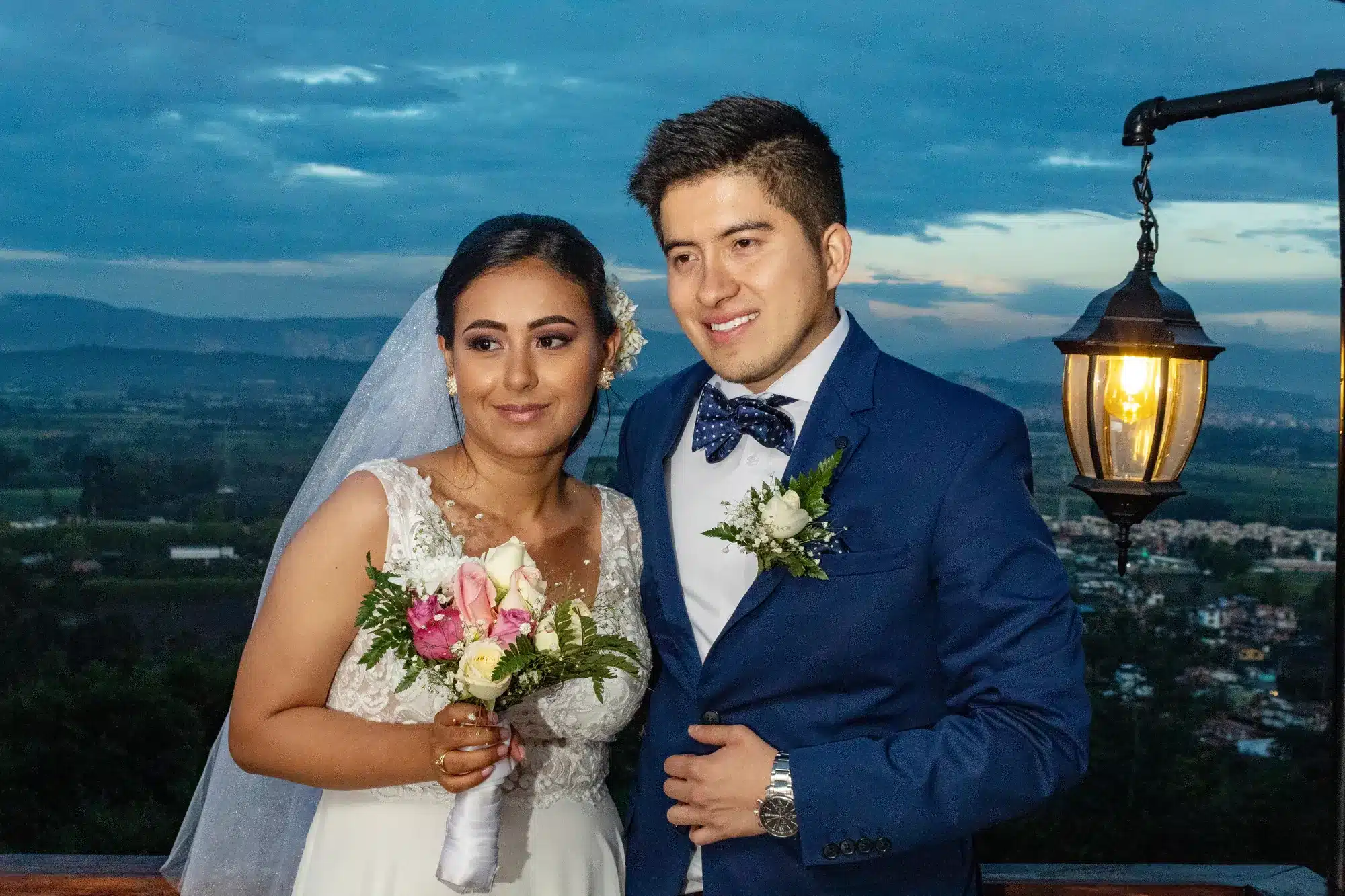 Novios con lámpara al atardecer sobre el valle