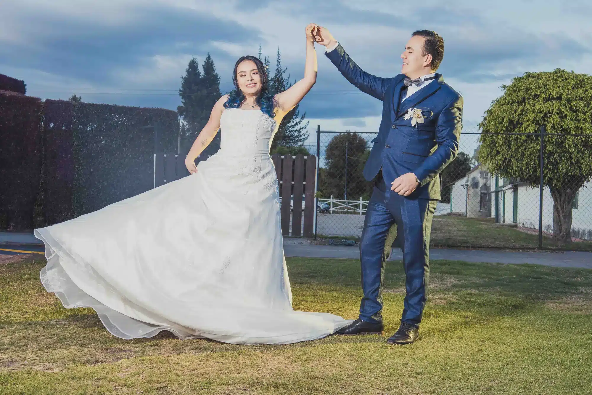 Novios girando en el jardín al atardecer
