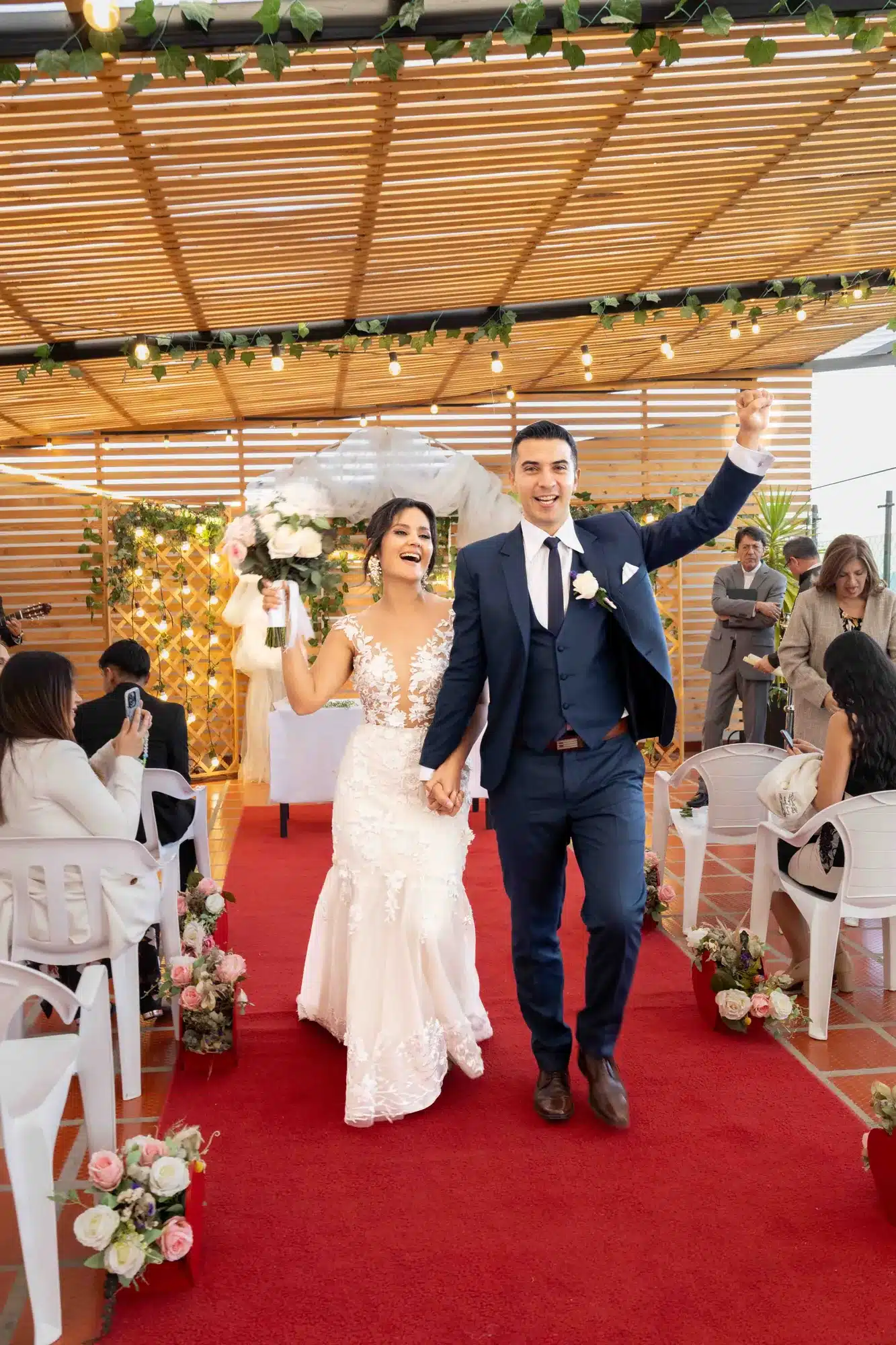 Novios saliendo de la ceremonia por el pasillo rojo