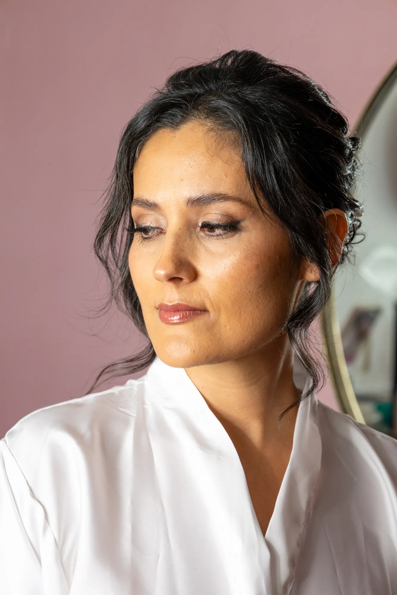 Retrato de novia en bata blanca mientras se prepara