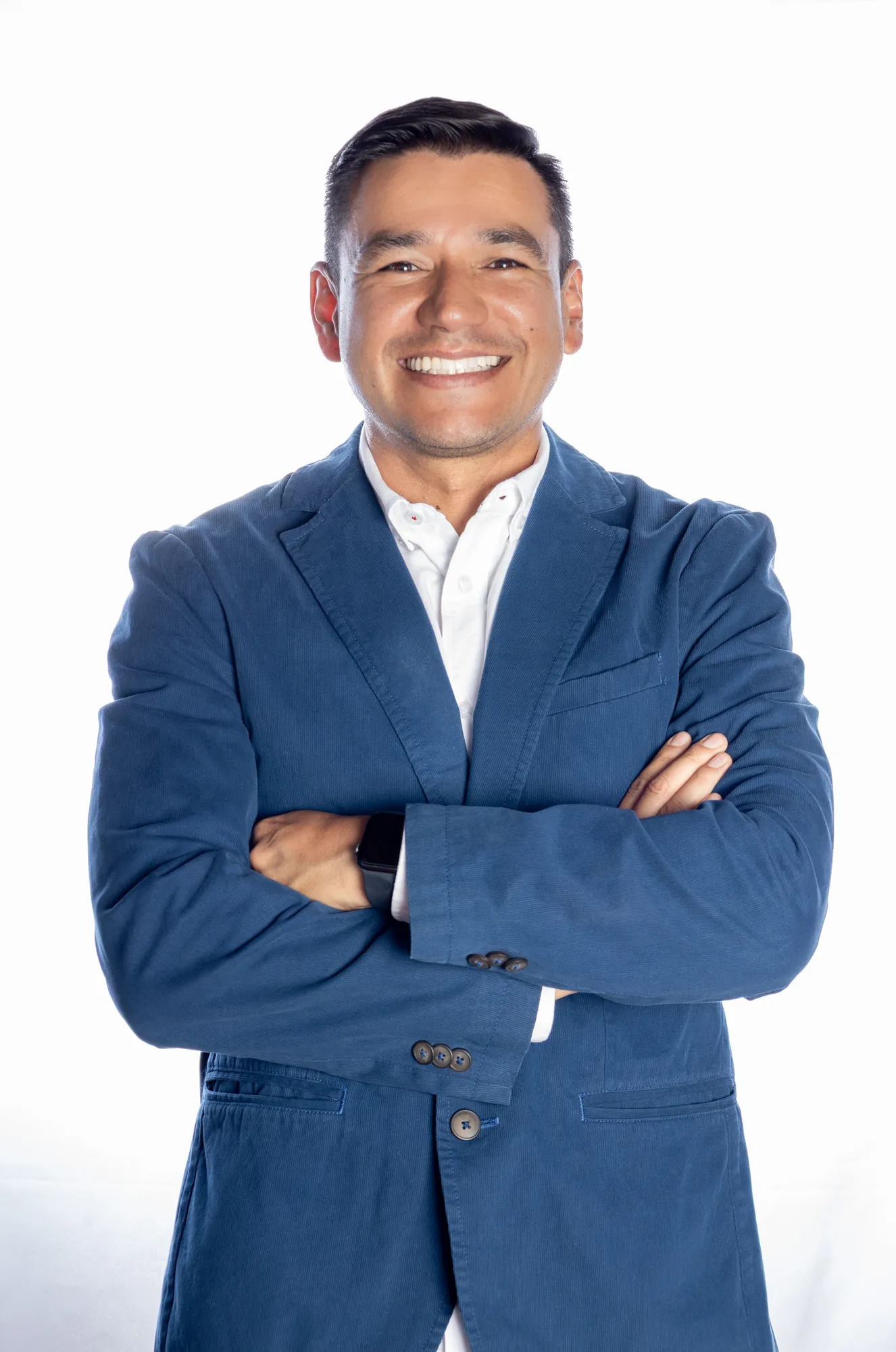 Retrato corporativo de hombre con saco azul y brazos cruzados