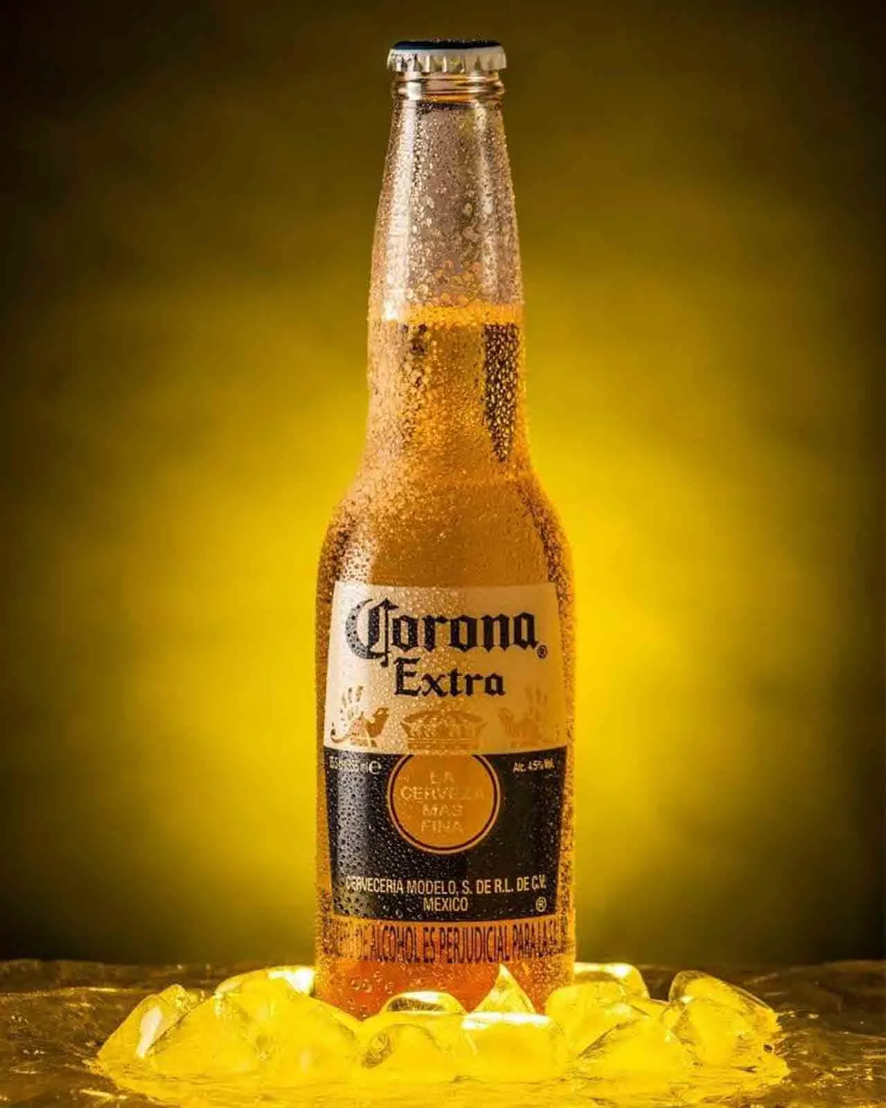 Cerveza con gotas de agua sobre hielo dorado