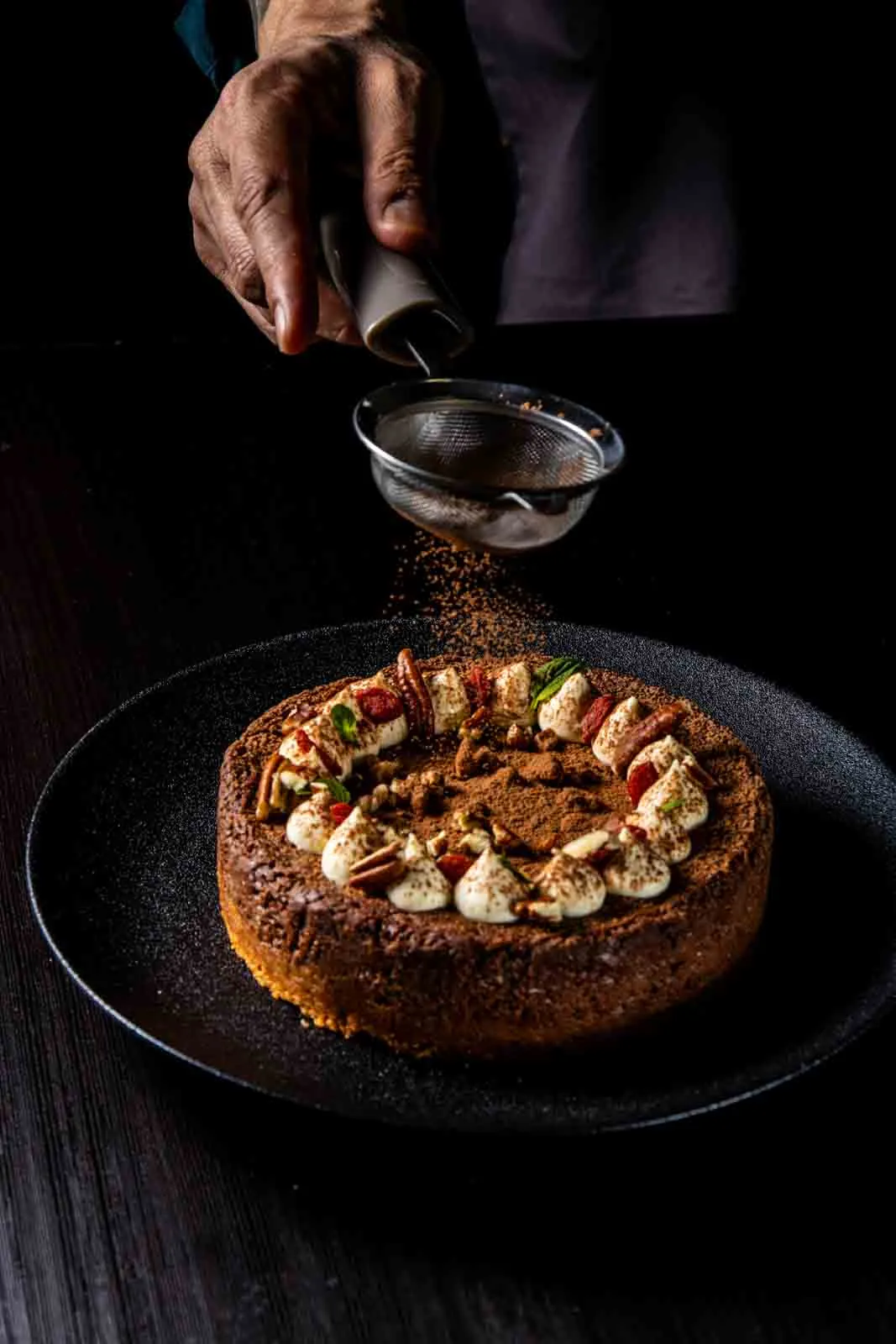 Espolvoreando cacao sobre una torta