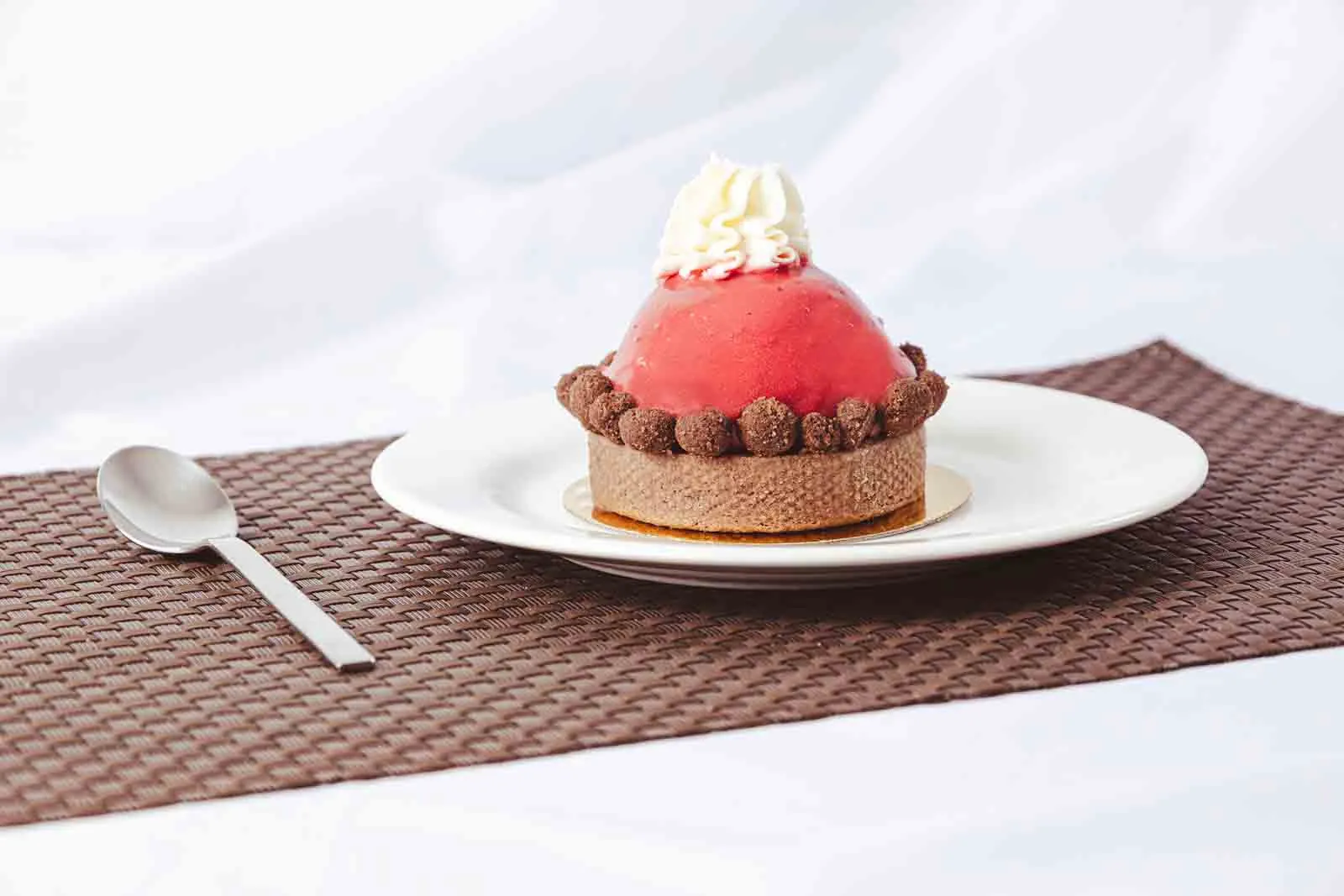 Postre de frutos rojos sobre mantel y cuchara