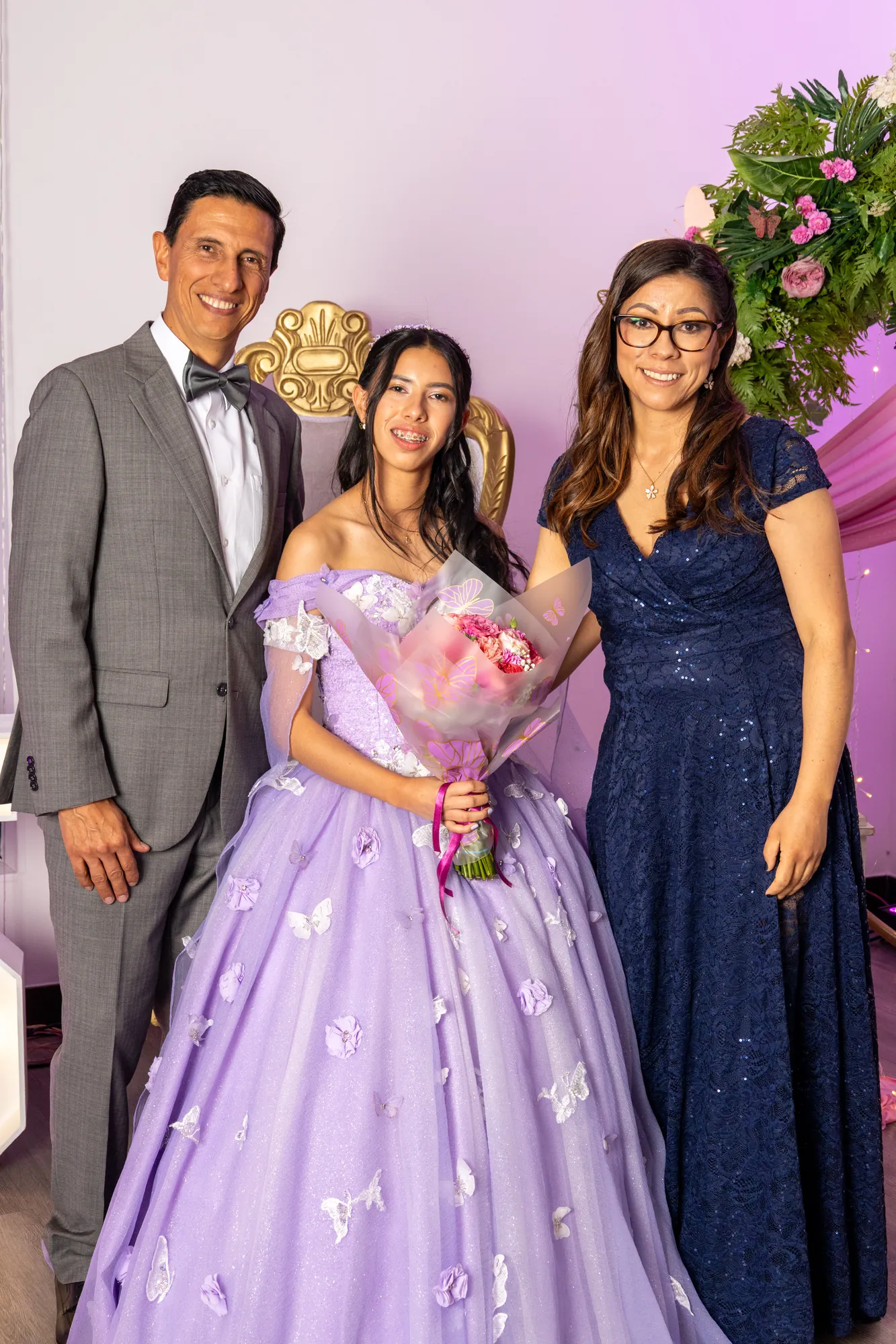 Quinceañera con sus padres en la fiesta
