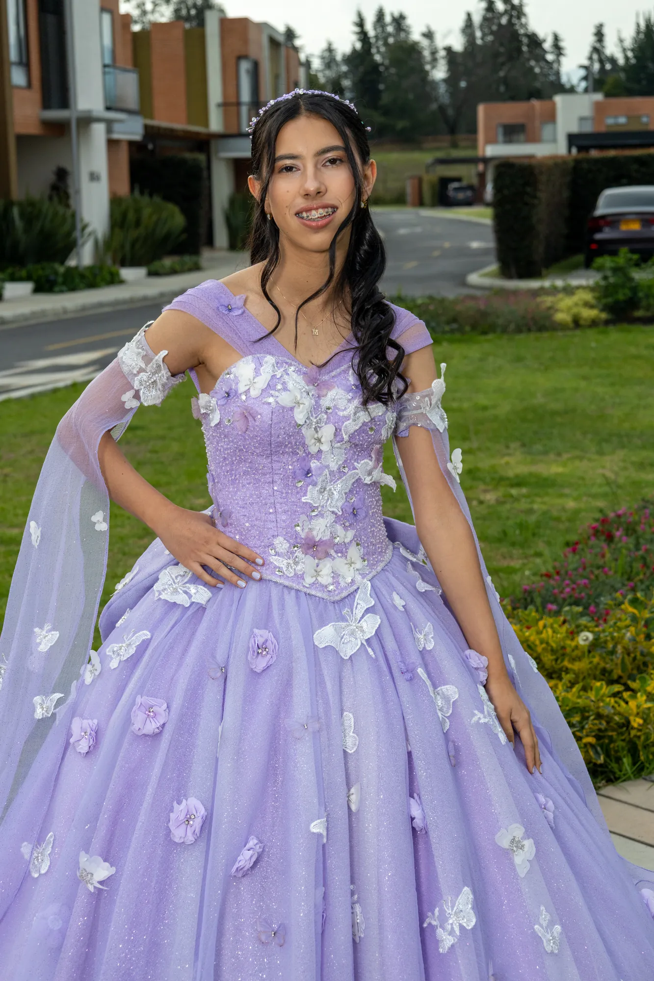 Quinceañera con vestido lila junto a un lago