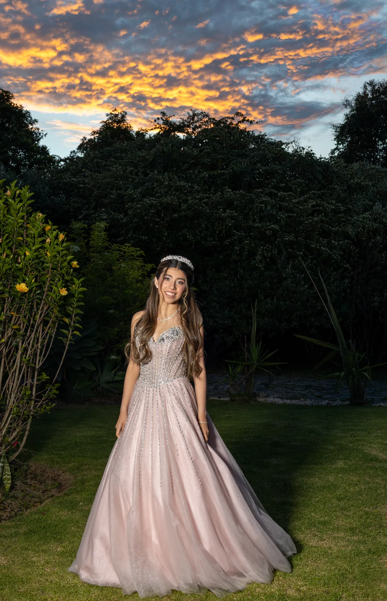 Quinceañera en un jardín al atardecer