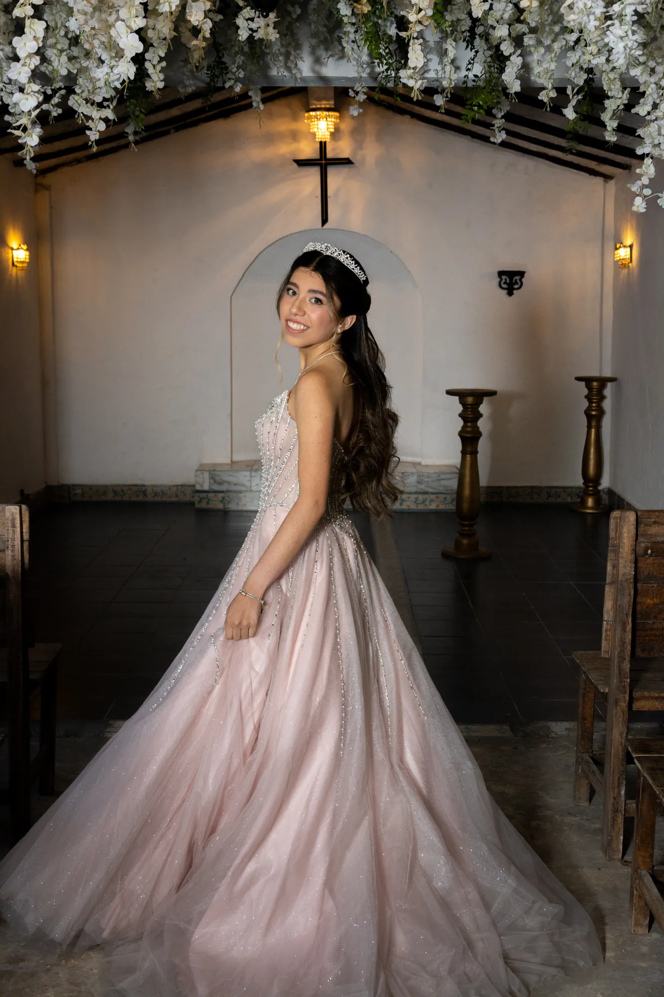 Quinceañera en una capilla decorada con flores